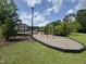 Community playground with various play structures, bordered by a black safety fence and lush greenery at 4104 Bankshire Ln, Raleigh, NC 27603
