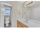 Well-lit bathroom featuring a sink, decorative mirror and lighting, and a toilet and shower with tiled walls at 430 Sir David Dr, Zebulon, NC 27597