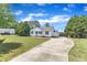 Inviting single-story home with a long driveway and detached carport surrounded by lush greenery at 430 Sir David Dr, Zebulon, NC 27597