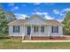 Charming single-story home with blue shutters, inviting front porch, and manicured landscaping at 430 Sir David Dr, Zebulon, NC 27597