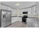 Bright kitchen featuring stainless steel appliances, granite counters, and white cabinetry at 430 Sir David Dr, Zebulon, NC 27597