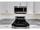 Close-up showcasing the stainless steel microwave and stove with granite countertops at 430 Sir David Dr, Zebulon, NC 27597
