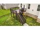 A charming wooden back deck with stairs leading to a beautifully maintained, green lawn and black metal fence at 4420 Bonnie Loch Dr, Burlington, NC 27215