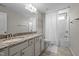 Bright bathroom featuring double sinks with a granite countertop, large mirror, and a shower with a curtain at 4420 Bonnie Loch Dr, Burlington, NC 27215