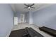 A bright blue bedroom that features a gray ceiling fan, and doorway looking into an open hall at 4420 Bonnie Loch Dr, Burlington, NC 27215