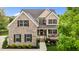 Two-story brick home with well-manicured landscaping and a charming front porch at 4420 Bonnie Loch Dr, Burlington, NC 27215