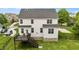 Aerial rear view of a two-story home with a wooden deck, black metal fence, and well-manicured lawn at 4420 Bonnie Loch Dr, Burlington, NC 27215
