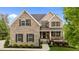 Charming brick home with manicured lawn, covered front porch, and detailed architectural features at 4420 Bonnie Loch Dr, Burlington, NC 27215