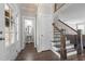 Bright foyer with wood floors, staircase with iron railing, and convenient powder room access at 4420 Bonnie Loch Dr, Burlington, NC 27215