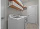 Bright laundry room with front loading machines, tile flooring and shelves at 4420 Bonnie Loch Dr, Burlington, NC 27215