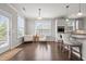 Bright living space with hardwood floors, white tufted chairs, and a breakfast bar with pendant lighting at 4420 Bonnie Loch Dr, Burlington, NC 27215