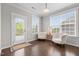 Bright sitting area with a door to the outside, two white chairs and large windows at 4420 Bonnie Loch Dr, Burlington, NC 27215