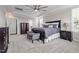 Spacious main bedroom features a dark wood bed frame, ceiling fan and large windows at 4420 Bonnie Loch Dr, Burlington, NC 27215