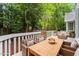 Outdoor deck with dining area, wicker chairs, and lush greenery at 5 Wembley Ct, Durham, NC 27705