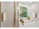 Bright bathroom features a tub, glass shower, and a window with a backyard view at 5 Wembley Ct, Durham, NC 27705