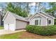 Side view of a gray single-story home featuring a two-car garage and manicured landscaping at 5 Wembley Ct, Durham, NC 27705