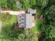 Aerial view of a home showcasing a large backyard, patio, mature trees, and a driveway at 5116 Knaresborough Rd, Raleigh, NC 27612