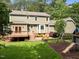 Aerial view of backyard with deck, patio seating, swing set, and greenery at 5116 Knaresborough Rd, Raleigh, NC 27612