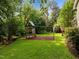Well-maintained backyard featuring a playground, swing set, and lush greenery at 5116 Knaresborough Rd, Raleigh, NC 27612