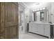 Bathroom featuring a double vanity, decorative lighting, and sliding barn door at 5116 Knaresborough Rd, Raleigh, NC 27612