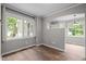 Bright bedroom with hardwood floors, large windows, and views into the living room at 5116 Knaresborough Rd, Raleigh, NC 27612