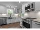 Well-lit kitchen featuring modern appliances, stainless steel sink and stylish white cabinets at 5116 Knaresborough Rd, Raleigh, NC 27612