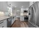 Modern, all-white kitchen with stainless steel appliances and updated fixtures at 5116 Knaresborough Rd, Raleigh, NC 27612