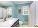 Charming bathroom boasts shiplap walls, hexagon tile floors, and a modern vanity with white countertop and a window at 520 Brittany Bay W, Raleigh, NC 27614