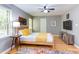Bedroom with wood bed frame, yellow accents, ceiling fan, hardwood floors, natural light, and TV at 520 Brittany Bay W, Raleigh, NC 27614