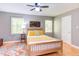Cozy bedroom with wood bed frame, yellow accents, ceiling fan, hardwood floors, and natural light at 520 Brittany Bay W, Raleigh, NC 27614