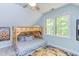 Cozy bedroom with a wooden bunk bed and soft patterned bedding, complemented by a yellow and gray textured rug at 520 Brittany Bay W, Raleigh, NC 27614