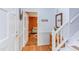 Bright foyer with hardwood floors, white wainscoting, stairs, and a view into a cozy room with a colorful accent wall at 520 Brittany Bay W, Raleigh, NC 27614