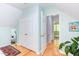 Hallway featuring hardwood floors leading to bedrooms, mirrored closet doors and white molding at 520 Brittany Bay W, Raleigh, NC 27614