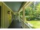 Inviting covered front porch with dark floors, white railings, and an inviting view of the surrounding greenery at 520 Brittany Bay W, Raleigh, NC 27614