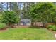 Backyard shed and play area surrounded by lush landscaping and a privacy fence at 520 Brittany Bay W, Raleigh, NC 27614