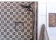Close-up of a shower with black and white patterned tile, a built-in niche, and a rainfall showerhead at 520 Brittany Bay W, Raleigh, NC 27614