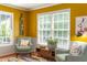 A sitting area features two armchairs, a colorful rug, natural light, and eye-catching yellow walls at 520 Brittany Bay W, Raleigh, NC 27614