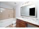 Bathroom featuring a tub with shower, granite counters, and wooden cabinets at 520 Camden Yards Way, Cary, NC 27519