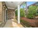 Covered patio with brick wall, white columns, and lush landscaping at 520 Camden Yards Way, Cary, NC 27519