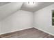 A minimalist bedroom with angled ceiling, natural light, and wood-look flooring at 5236 Turf Grass Ct, Raleigh, NC 27610