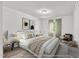 Staged main bedroom with soft bedding, modern lamps and chair at 5236 Turf Grass Ct, Raleigh, NC 27610