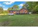 Exterior view of the home and backyard featuring a wooden deck, storage tank, and a well-maintained lawn at 586 New Hope Church Rd, Apex, NC 27523