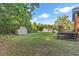 Backyard view showcasing the deck, outbuilding, and lush greenery creating a serene outdoor space at 586 New Hope Church Rd, Apex, NC 27523
