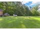 Lush backyard featuring a storage shed and mature trees, offering privacy and room for outdoor activities at 586 New Hope Church Rd, Apex, NC 27523