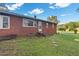 Backyard view of a brick home with a small porch and lawn at 586 New Hope Church Rd, Apex, NC 27523