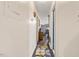 Hallway with white walls and hardwood floors leads to the kitchen with stainless steel appliances at 586 New Hope Church Rd, Apex, NC 27523