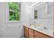 Well-lit bathroom with double sinks, a mirror, and a bright window at 5939 Florasaline Dr, Mebane, NC 27302