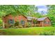 Charming brick home with lush green lawn and mature trees providing shade and curb appeal at 5939 Florasaline Dr, Mebane, NC 27302