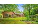 Brick home featuring a meticulously maintained lawn and an inviting, landscaped front yard at 5939 Florasaline Dr, Mebane, NC 27302