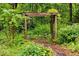 Lush garden featuring a charming wooden arbor and a stone pathway at 5939 Florasaline Dr, Mebane, NC 27302